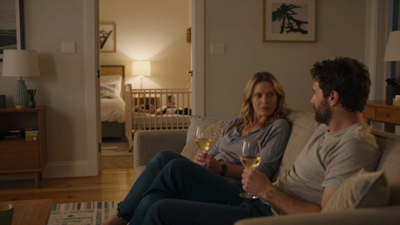 Parents relaxing in a living room while a toddler sleeps in a separate bedroom.